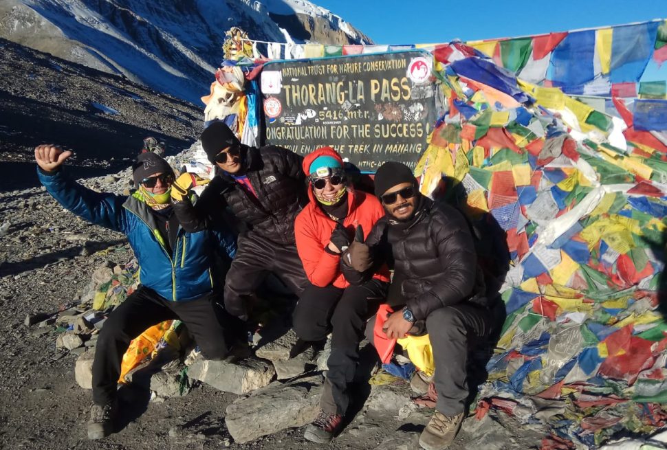 Lead guide Ajit at Thorong La Pass with group of trekkers