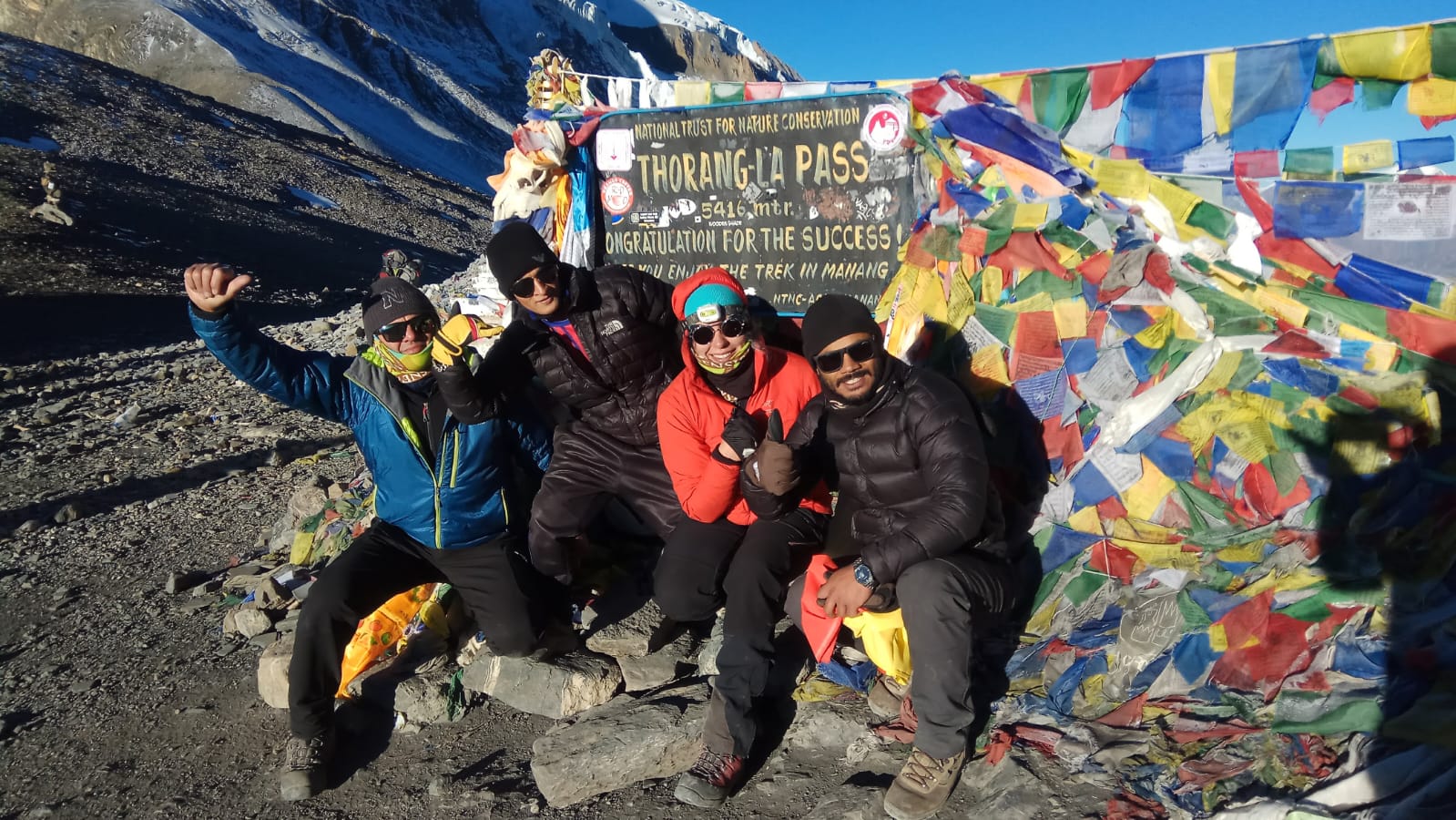 Lead guide Ajit at Thorong La Pass with group of trekkers