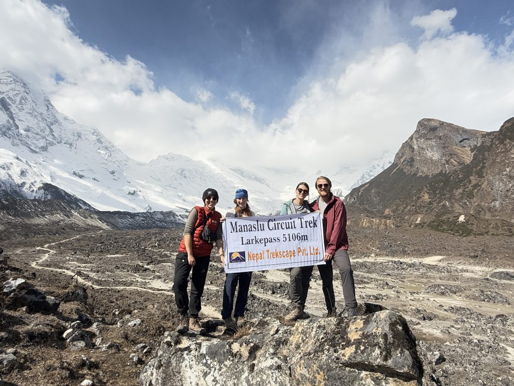 Trekkers holding banner of Nepal Trekscape on the way to Pungyen Gompa