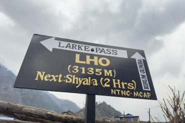 Signboard showing Lho Village at an elevation of 3135 meters on the Manaslu Circuit Trek route