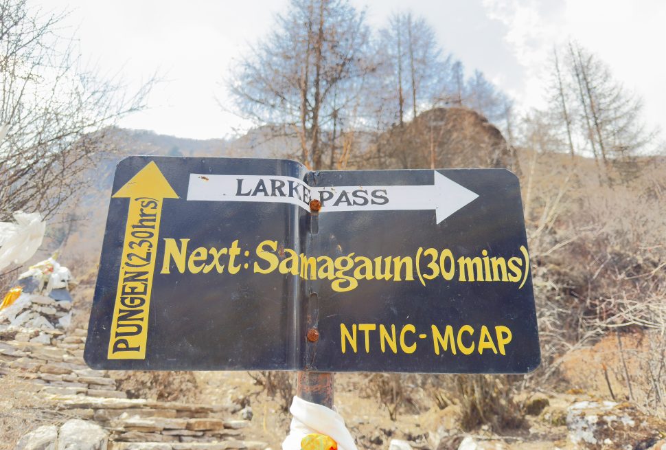 Trail sign near Samagaun pointing toward Larke Pass and Pungen on the Manaslu Circuit Trek in Nepal.
